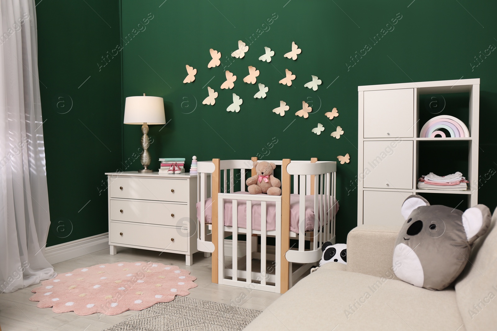 Photo of Beautiful baby room interior with stylish furniture and comfortable crib