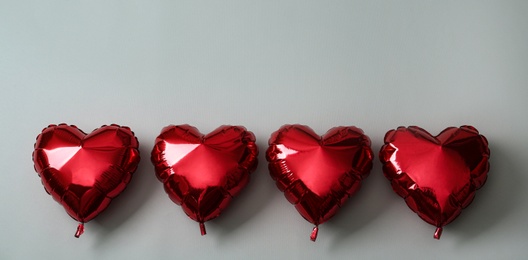Photo of Red heart shaped balloons on grey background. Valentine's Day celebration