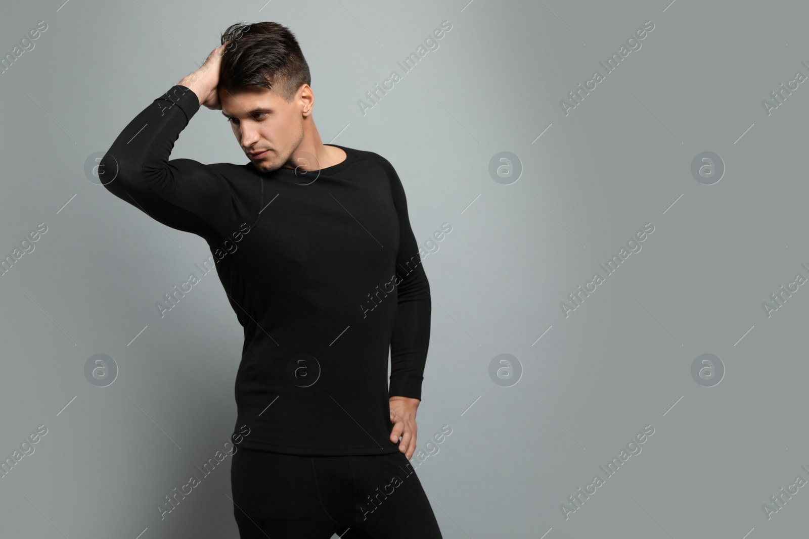 Photo of Man wearing thermal underwear on grey background. Space for text