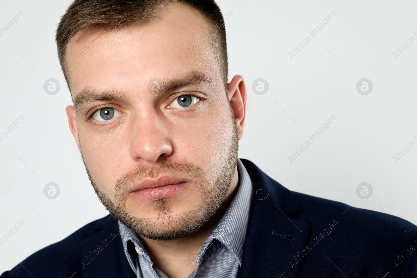 Photo of Portrait of young businessman on light background