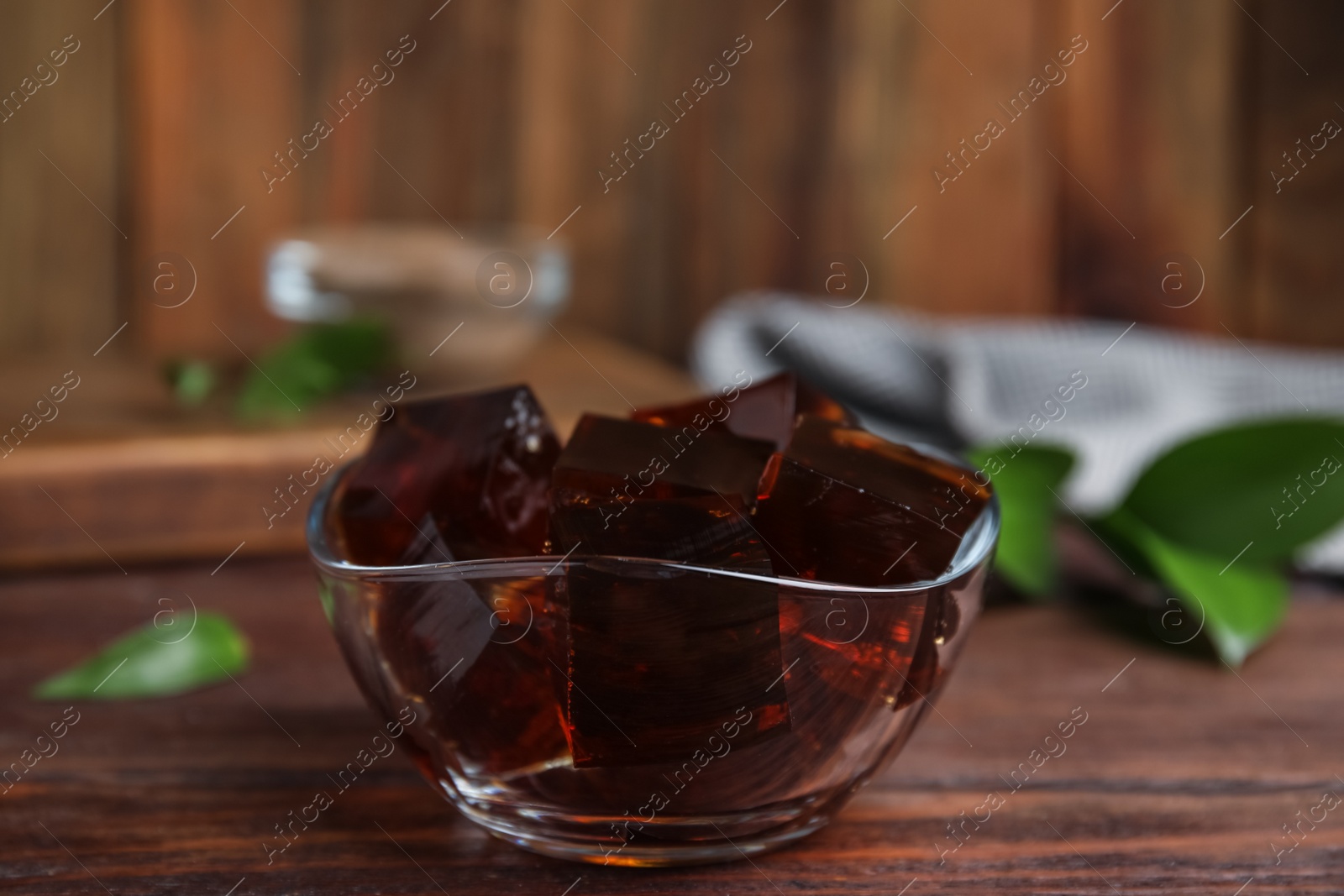 Photo of Delicious grass jelly cubes on wooden table, closeup