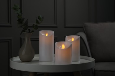 Photo of Decorative LED candles on white table in room