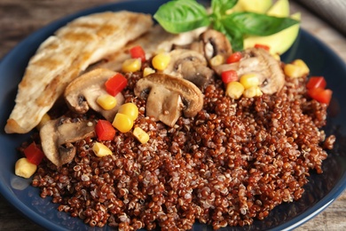 Photo of Plate with quinoa and garnish on table, closeup