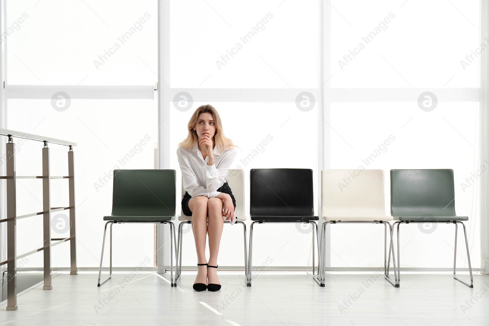 Photo of Young woman waiting for job interview in office hall