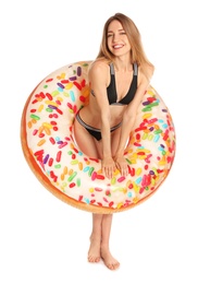 Beautiful young woman in stylish bikini with doughnut inflatable ring on white background