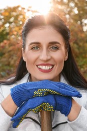 Woman wearing gloves and having rest after working in garden