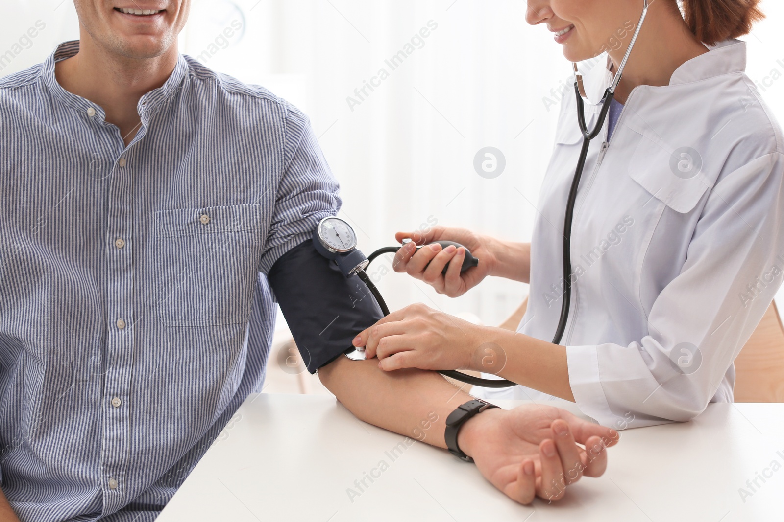 Photo of Doctor checking patient's blood pressure in hospital, closeup. Cardiology concept