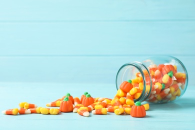 Photo of Jar with delicious candies on table against wooden background. Space for text