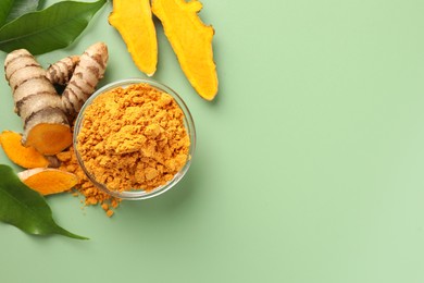 Aromatic turmeric powder, raw roots and leaves on green background, flat lay. Space for text