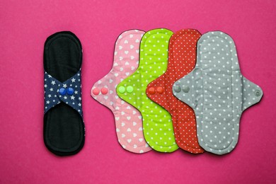Photo of Many reusable cloth menstrual pads on pink background, flat lay