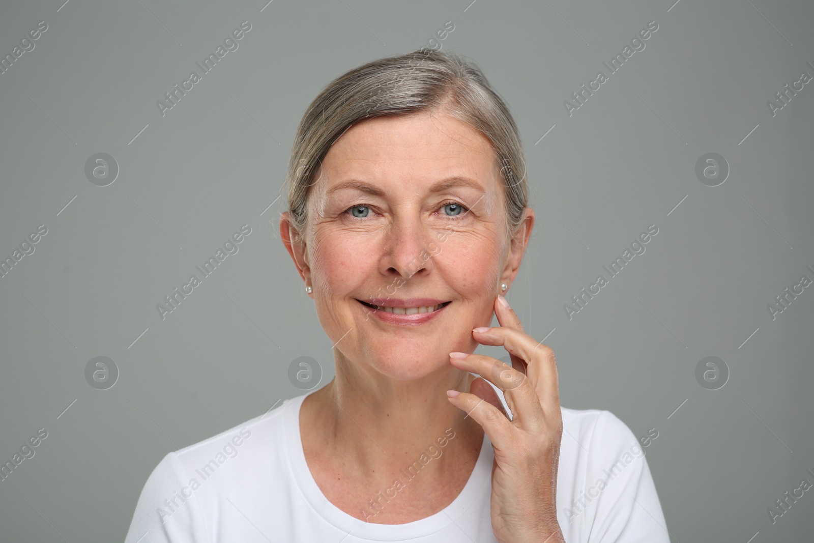 Photo of Portrait of senior woman with aging skin on grey background. Rejuvenation treatment