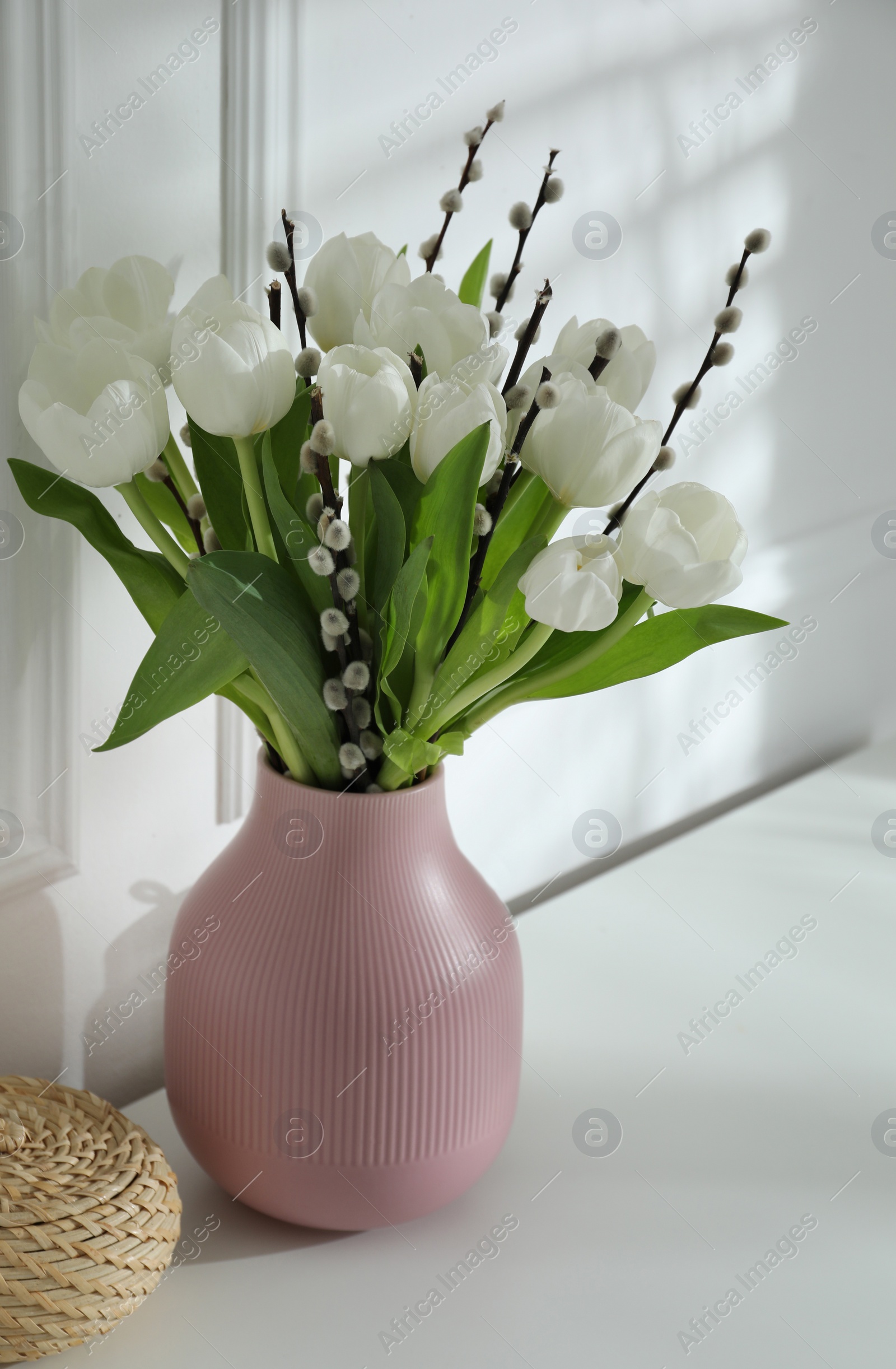 Photo of Beautiful bouquet of willow branches and tulips in vase indoors