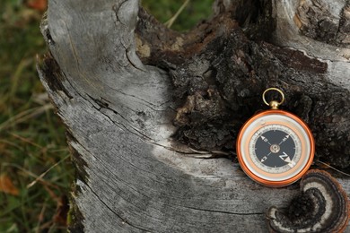 Photo of Compass on log, space for text. Navigation device