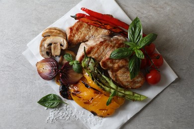 Photo of Tasty grilled meat and vegetables on light grey table, top view