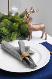 Photo of Festive place setting with beautiful dishware and fabric napkin for Christmas dinner on white table