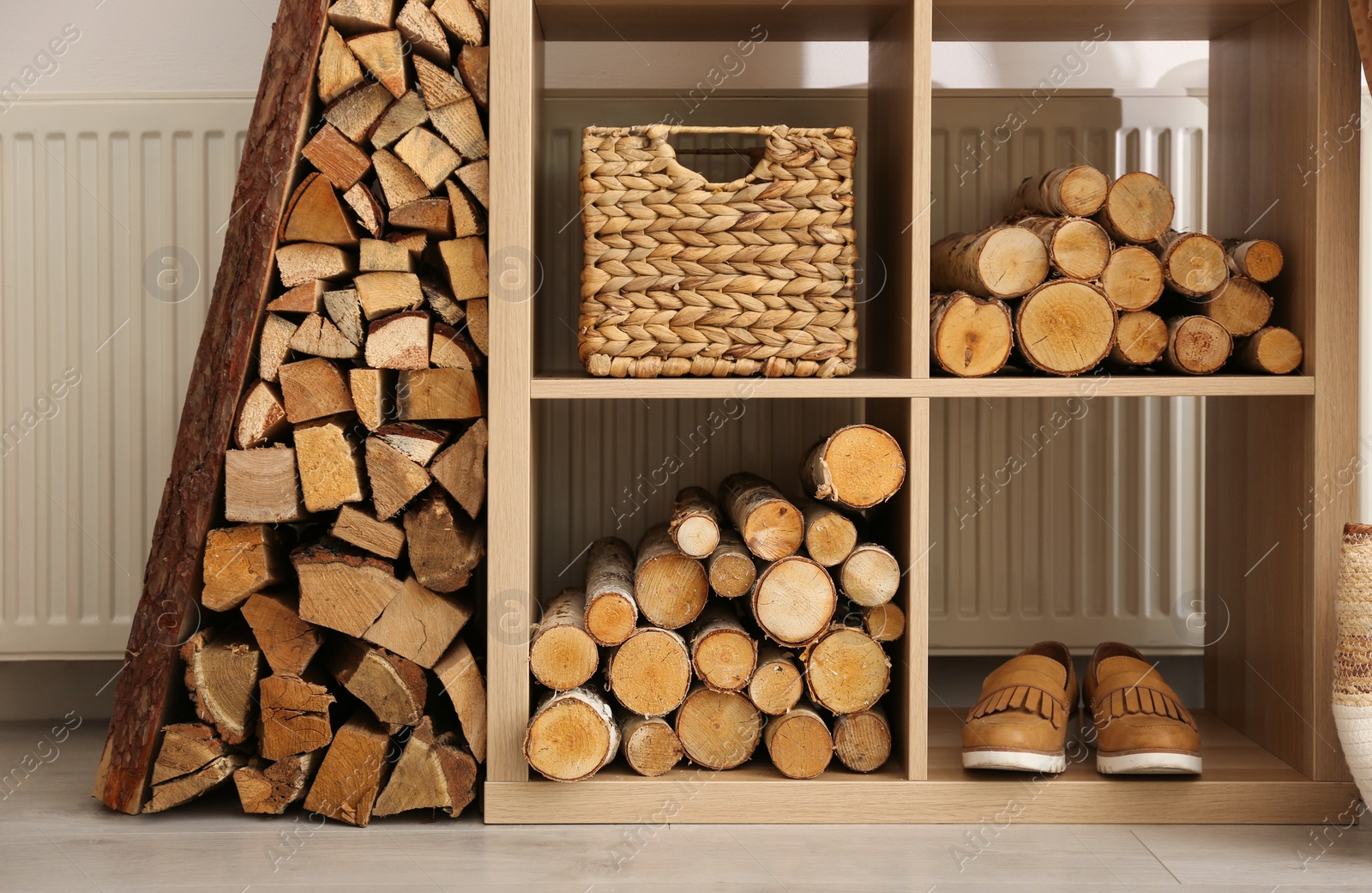 Photo of Shelving unit with firewood indoors. Interior design