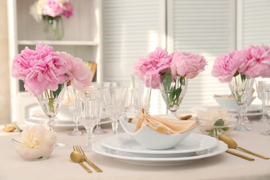 Photo of Stylish table setting with beautiful peonies and fabric napkin indoors