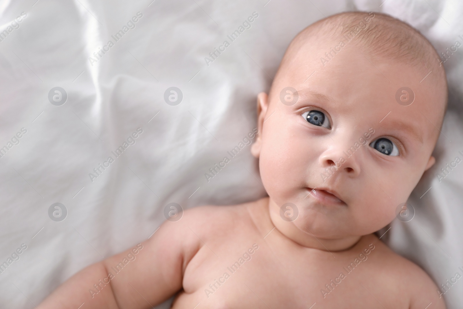 Photo of Cute little baby lying on bed, top view