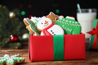 Tasty Christmas cookies in gift box on wooden table, closeup
