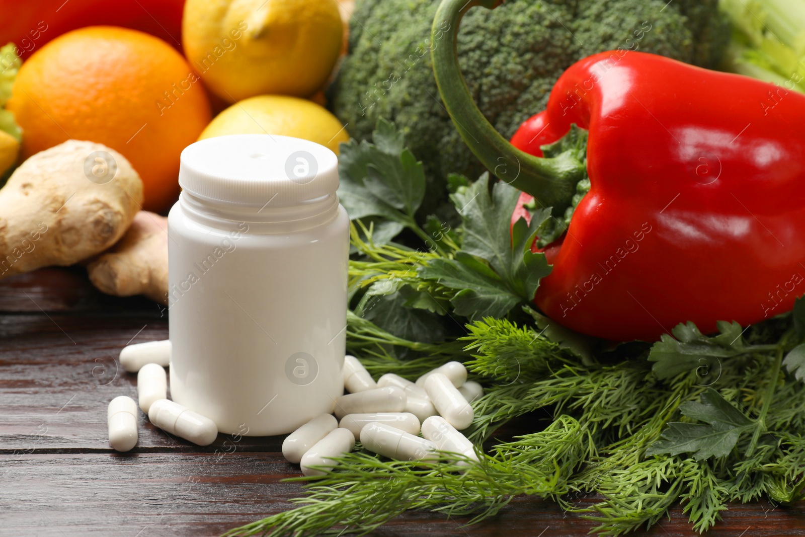 Photo of Dietary supplements. Plastic bottle, pills and food products on wooden table