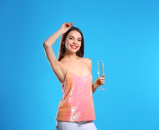 Photo of Portrait of happy woman with champagne in glass on color background