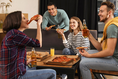 Photo of Groupfriends having fun party with delicious pizza in cafe