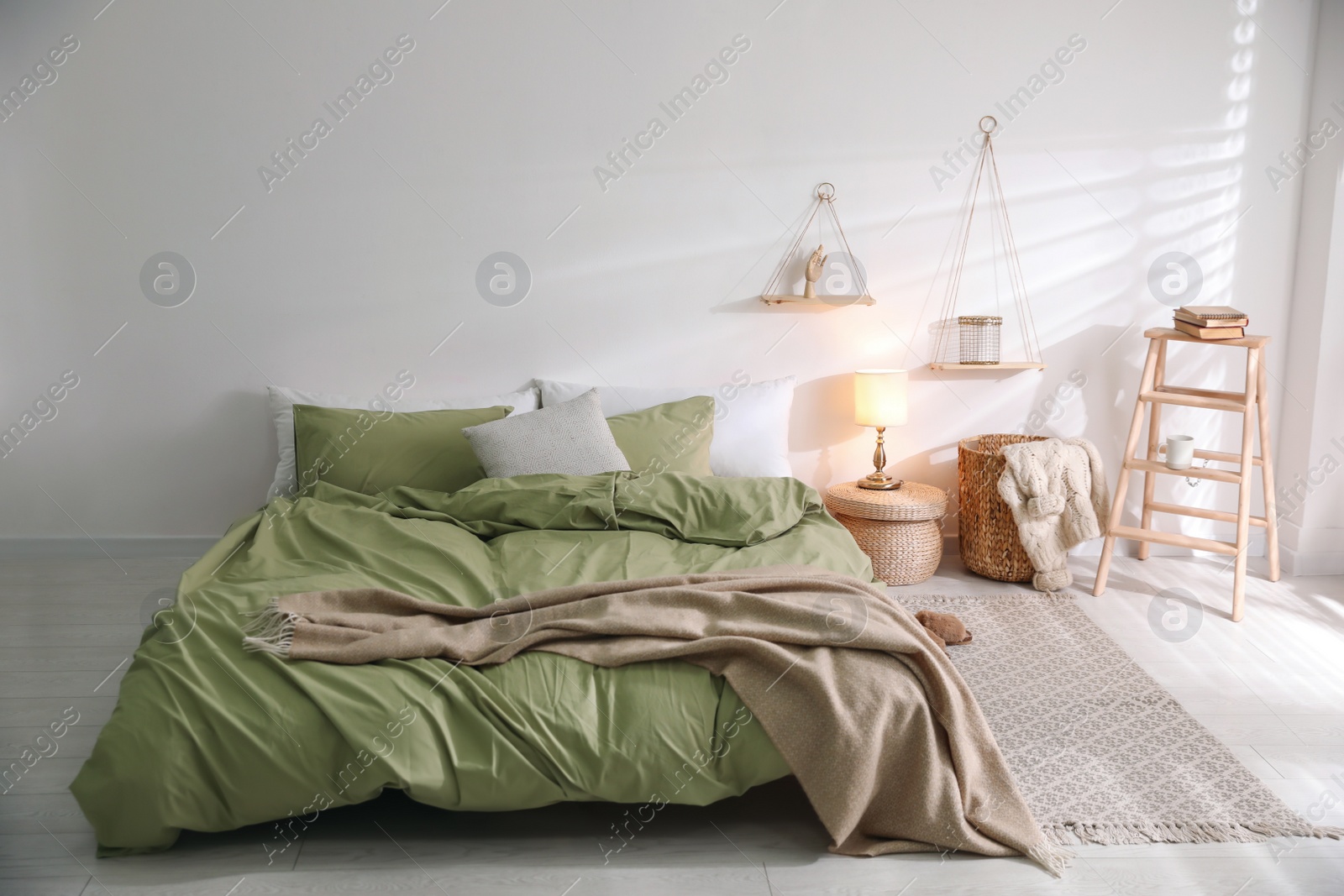 Photo of Comfortable bed with olive green linen in modern room interior