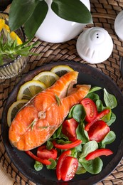 Healthy meal. Tasty grilled salmon with vegetables and lemon served on wicker mat, flat lay