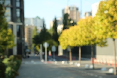 Photo of Blurred view of quiet city street with buildings and beautiful trees