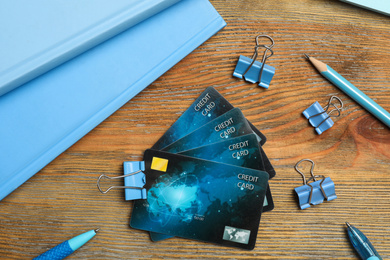 Photo of Flat lay composition with credit cards and stationery on wooden background
