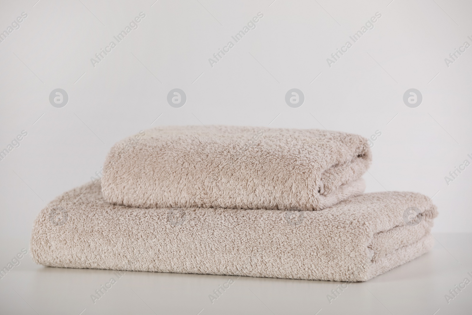 Photo of Soft folded towels and on white table