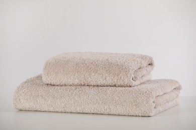 Photo of Soft folded towels and on white table