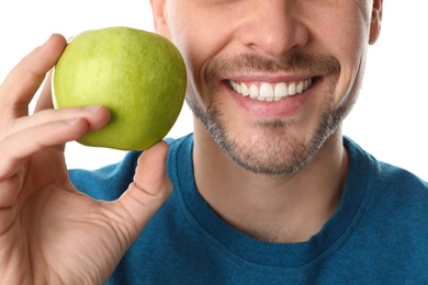 Photo of Man with perfect teeth and green apple on white background, closeup