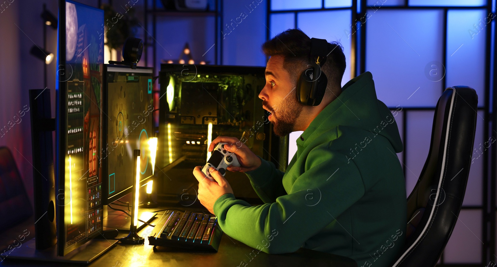 Photo of Man playing video games with controller at table indoors