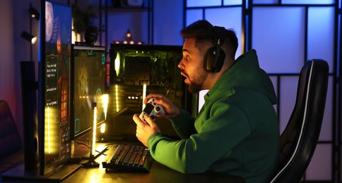 Man playing video games with controller at table indoors