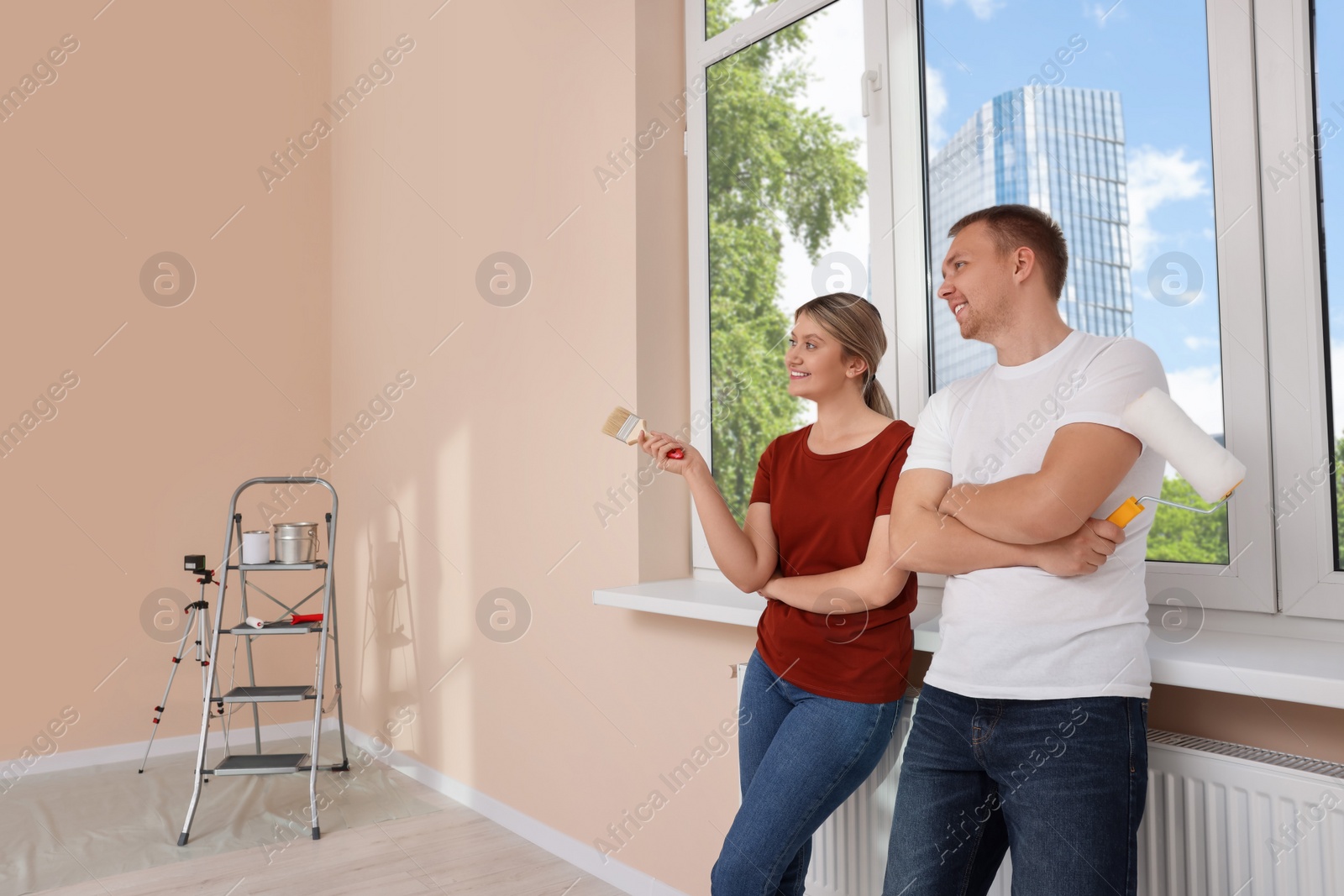 Photo of Happy couple discussing interior details in apartment during repair