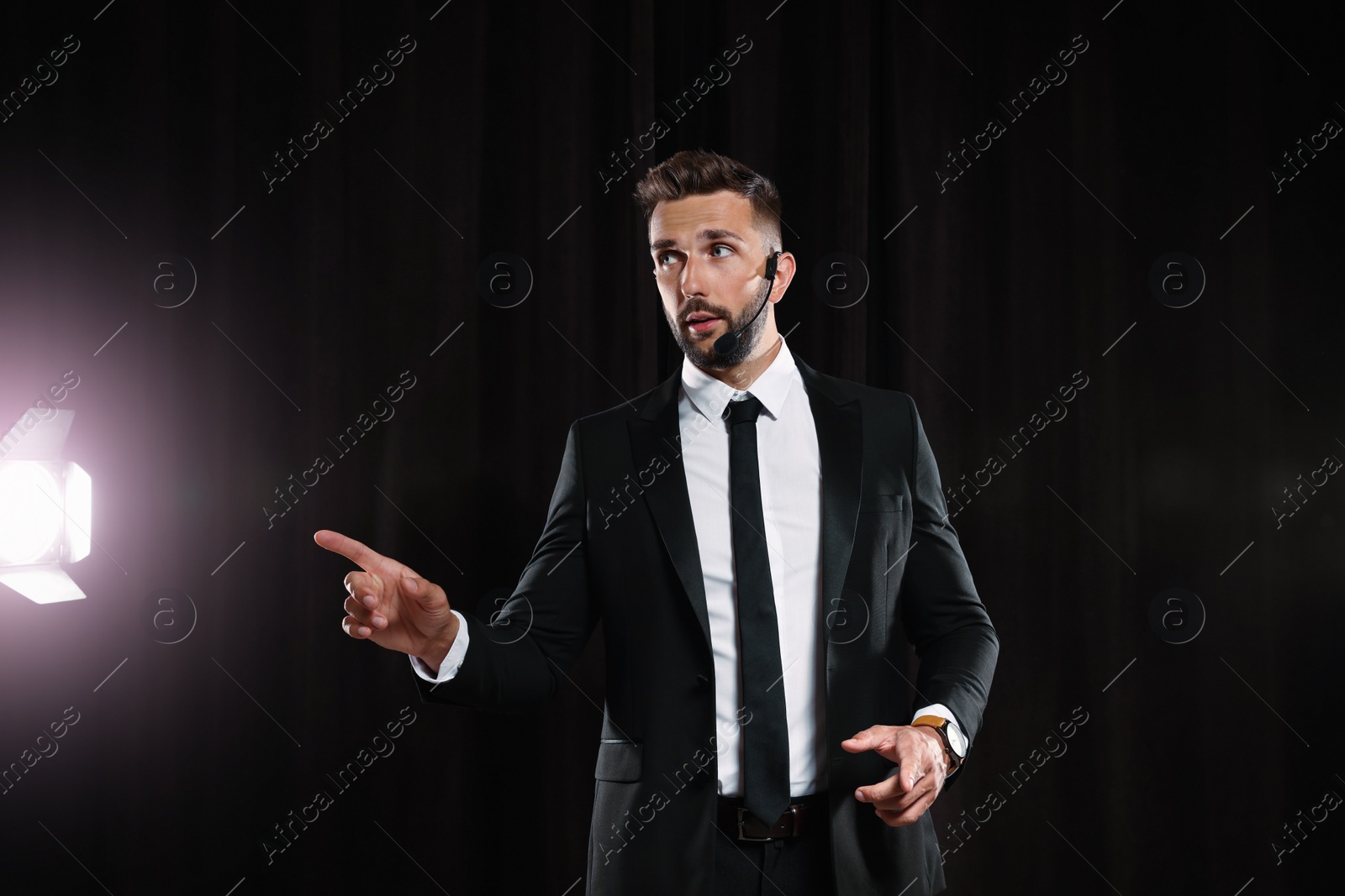 Photo of Motivational speaker with headset performing on stage