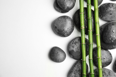 Photo of Wet zen stones and bamboo on white background, top view with space for text