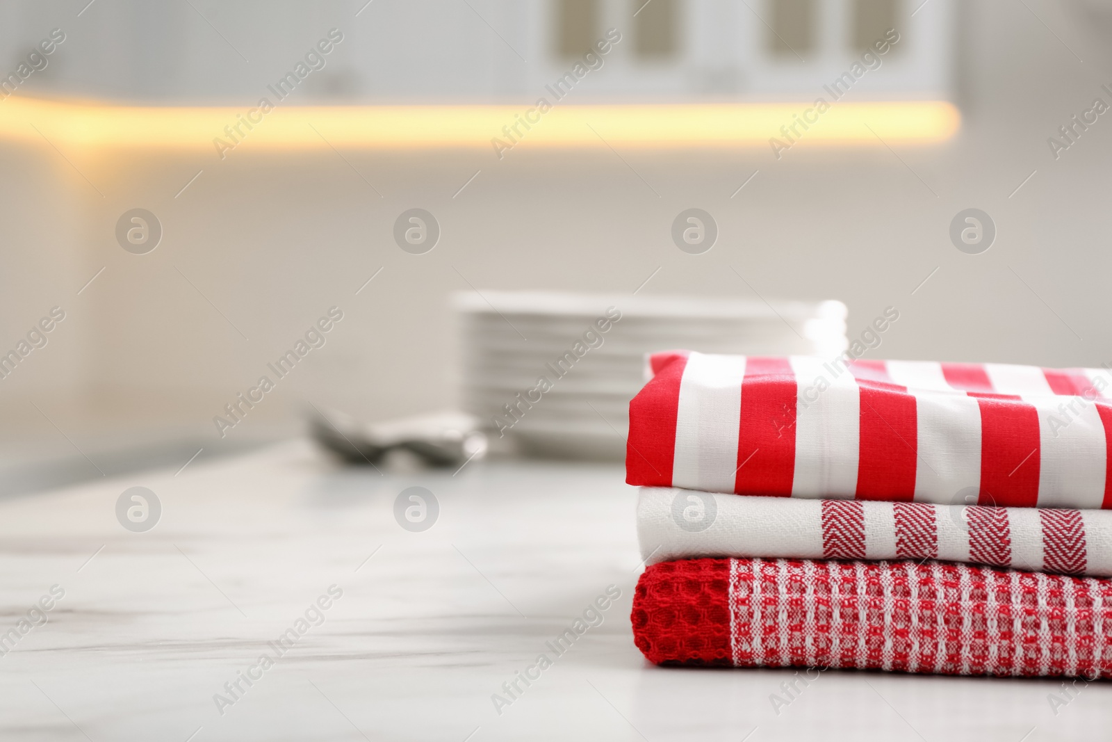 Photo of Stack of soft kitchen towels on white table indoors, space for text