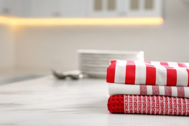 Stack of soft kitchen towels on white table indoors, space for text