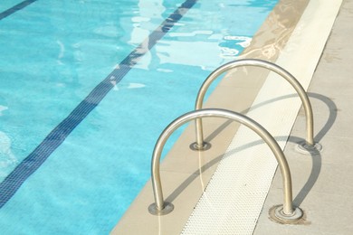 Ladder with handrails in outdoor swimming pool
