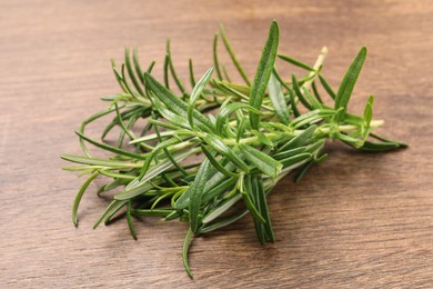 Fresh green rosemary on wooden table, closeup