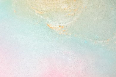 Colorful foam after dissolving bath bomb in water, closeup