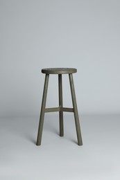 Photo of Stylish wooden stool on light grey background. Interior element