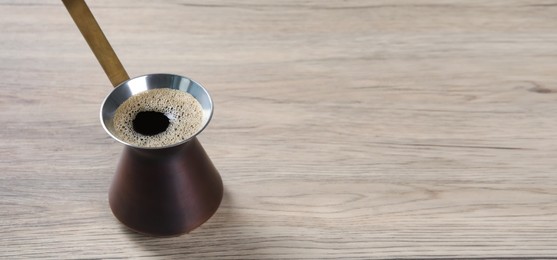 Image of Turkish coffee. Cezve on wooden table. Banner design with space for text