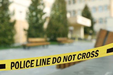 Image of Yellow crime scene tape blocking way in park