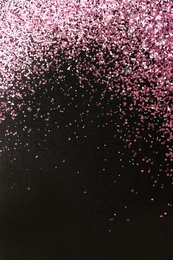 Photo of Rose gold glitter on black background, top view with space for text