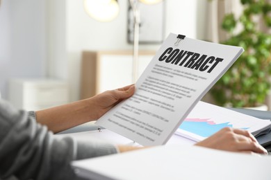 Image of Government contract. Woman reading document at table, closeup