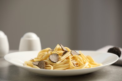 Photo of Tasty fettuccine with truffle on grey table