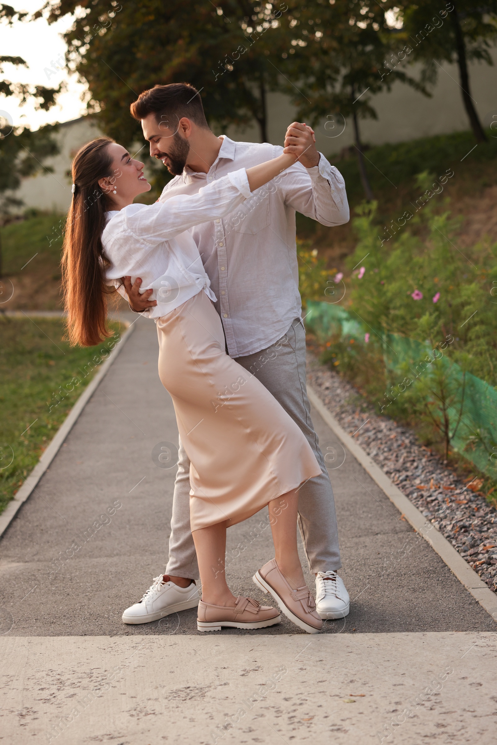 Photo of Lovely couple dancing together outdoors at sunset